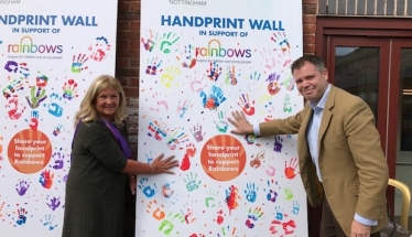 Edward and Rainbows Chair of Trustees hand-print the supporters wall